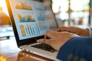 A close-up of a professional’s hands on a laptop displaying vibrant data visualizations and charts, symbolizing how Atypical Forte uncovers the strategic narrative within a hotel's GDS analytics.